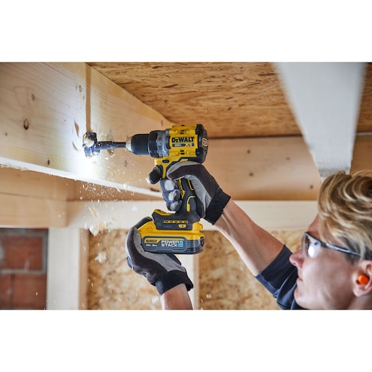 Drill being used overhead with DEWALT POWERSTACK five amp hour battery 