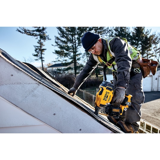 Cordless Coil Roofing Nailer being used by a person on top of a roof