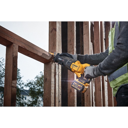 Brushless Cordless Reciprocating Saw with FLEXVOLT ADVANTAGE being used on a wooden frame structure outdoors